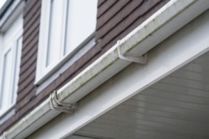 Photo of gutter leaking behind siding