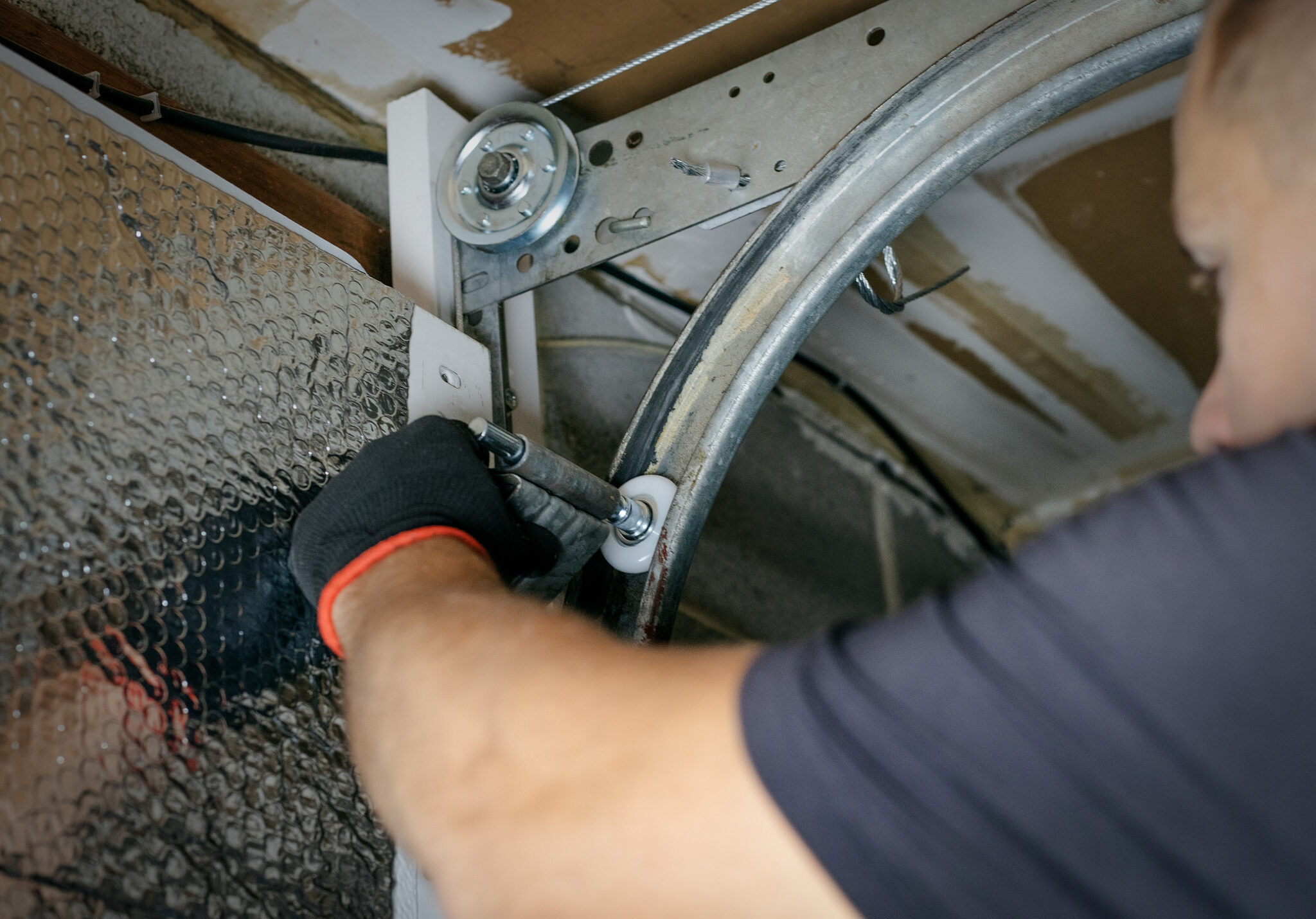 Close-up of a worker making repairs after identifying garage door problems